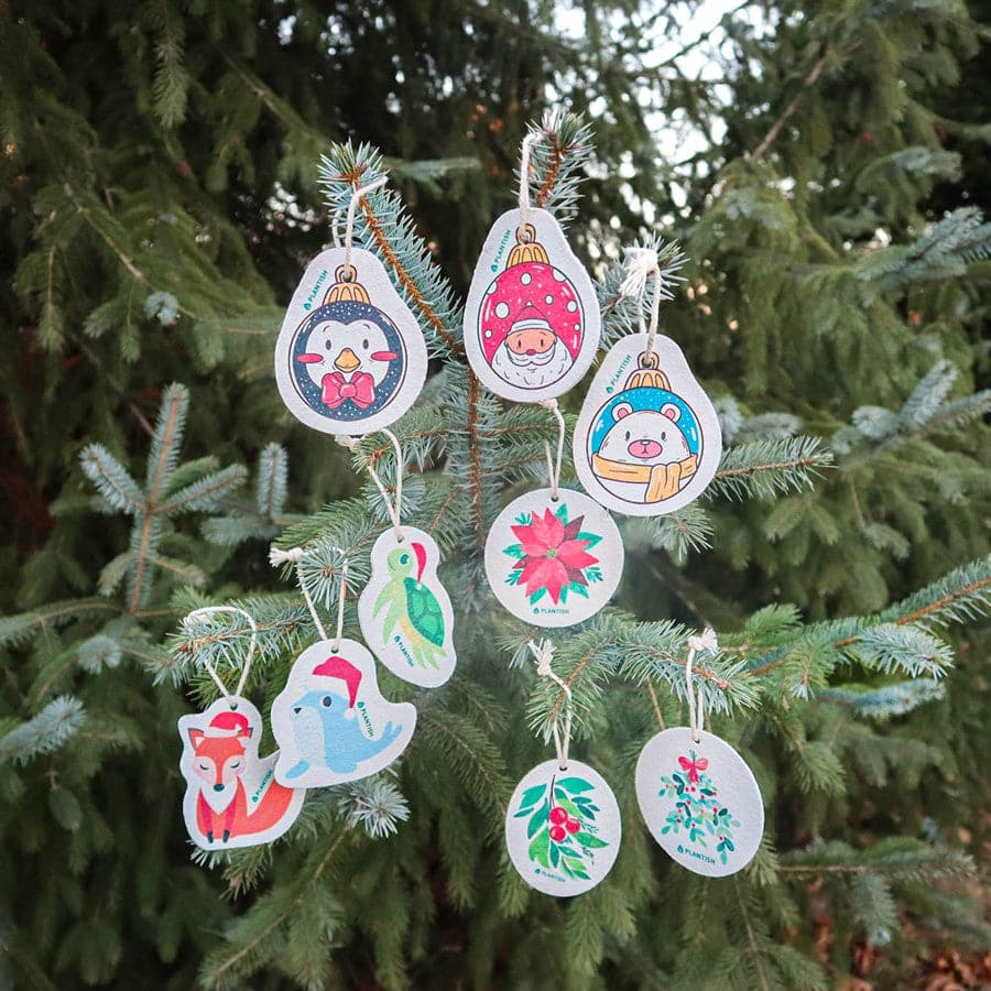 Decorative Christmas ornaments hanging on a tree with a green background