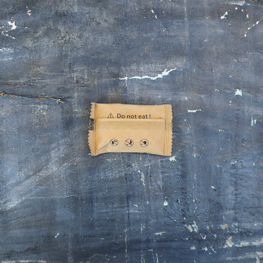 Brown paper bag with 'Do not eat!' text on a textured blue surface