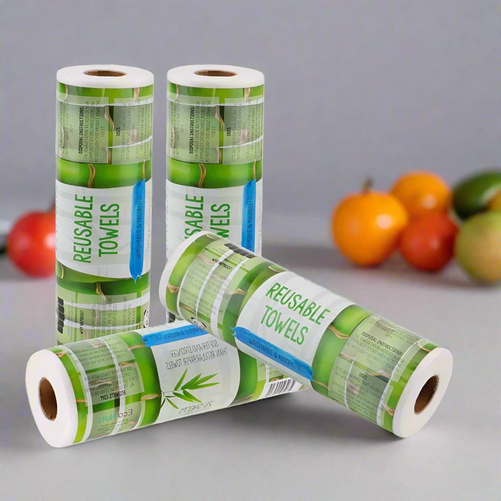 EcoNest Kitchen's roll of 25 reusable bamboo cleaning cloths next to a kitchen sink with soapy dishes