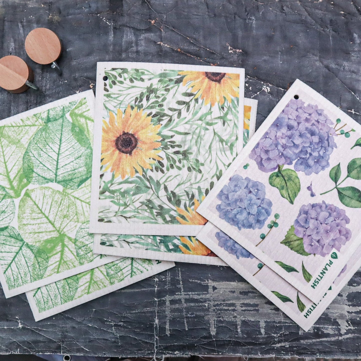 Set of floral and leaf-themed cards on a textured surface