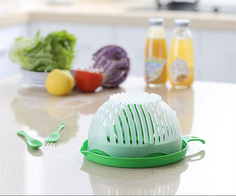 Green kitchen tool on a counter with fruits and drinks in the background