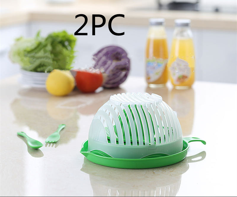Green kitchen tool on a countertop with vegetables and drinks in the background