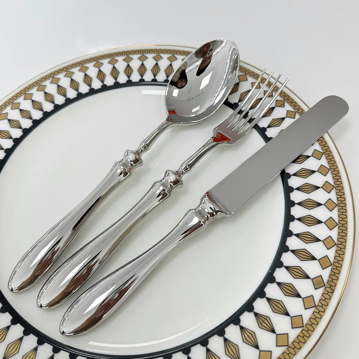 Stainless steel knife, fork, and spoon set by EcoNest Kitchen displayed on eco-conscious table setting
