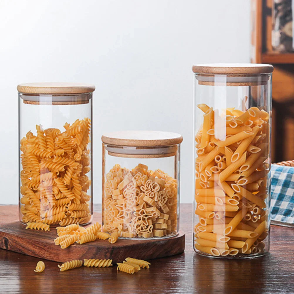 A collection of EcoNest Kitchen glass canisters with wooden lids, showcasing airtight seals for optimal food storage and organization.