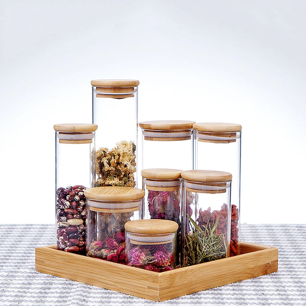 A collection of EcoNest Kitchen glass canisters with wooden lids, showcasing airtight seals for optimal food storage and organization.