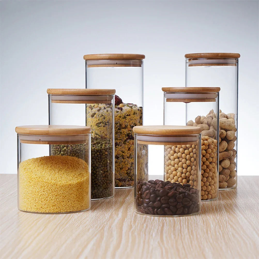 A collection of EcoNest Kitchen glass canisters with wooden lids, showcasing airtight seals for optimal food storage and organization.