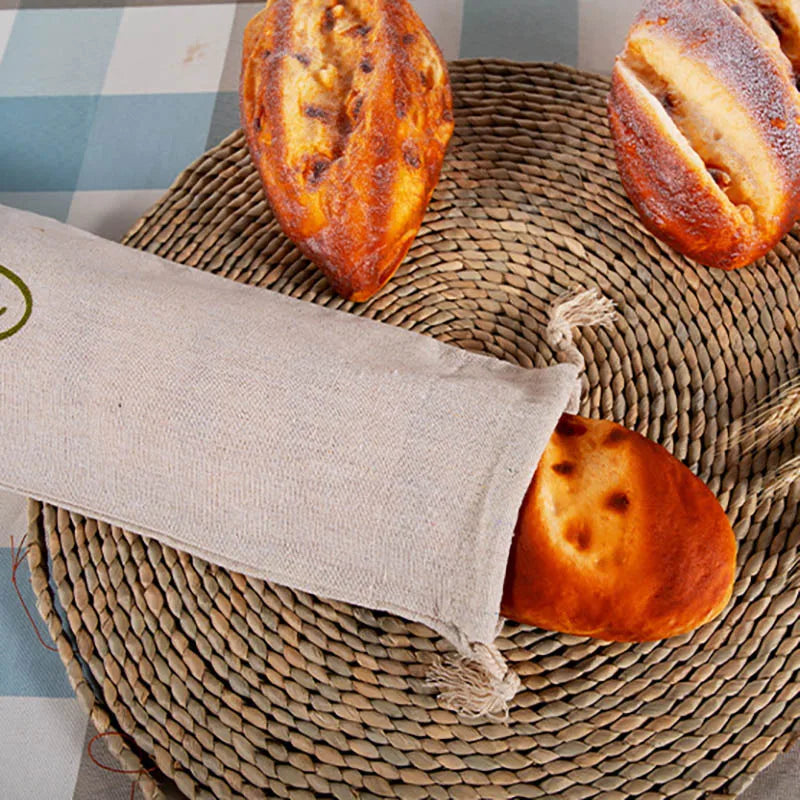 EcoNest reusable linen bread bag with drawstring, holding artisan bread on kitchen counter