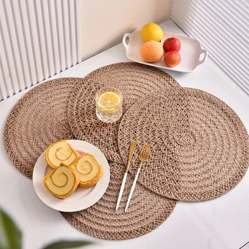 Round woven placemats on a table with food and cutlery