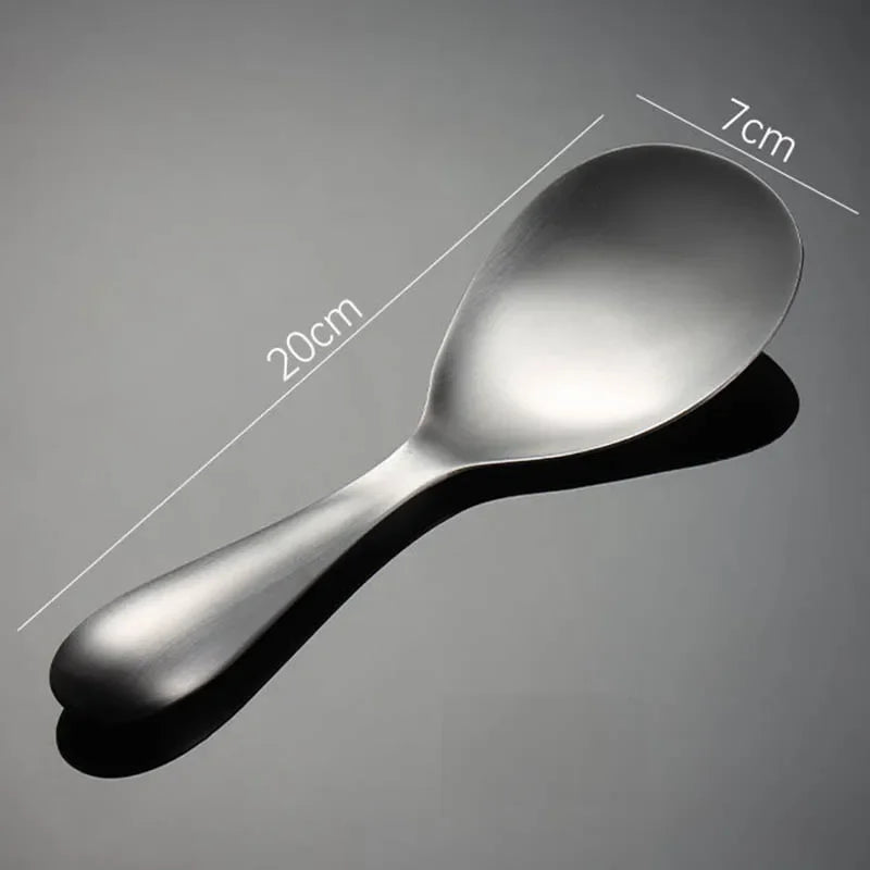 Stainless steel rice scoop with measurements on a gray background