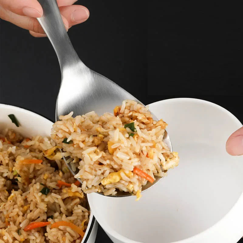 Spoonful of fried rice with vegetables over a bowl of fried rice.