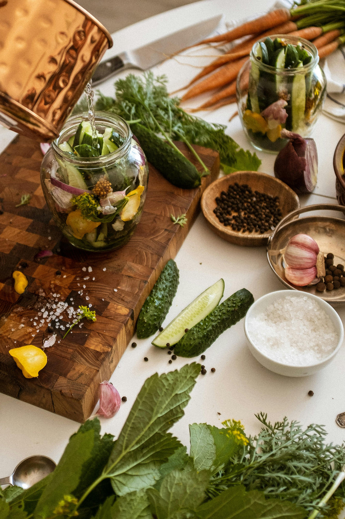 Eco-friendly bamboo kitchen utensils, bowls, and cutting boards displayed on a sustainable wooden countertop.