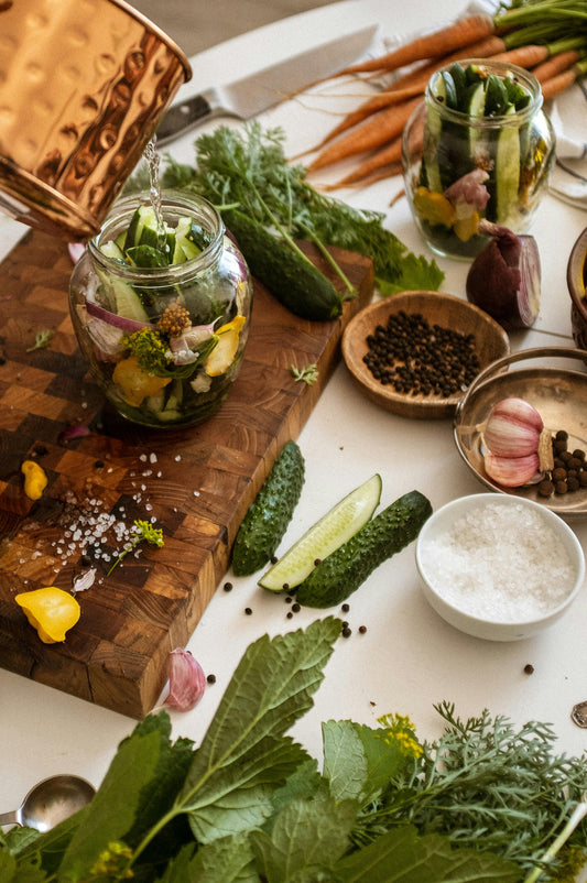 Eco-friendly bamboo kitchen utensils, bowls, and cutting boards displayed on a sustainable wooden countertop.