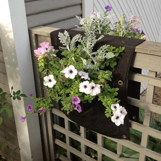 Eco-friendly 2-pocket saddlebag planter hanging on a balcony railing with herbs growing from both sides