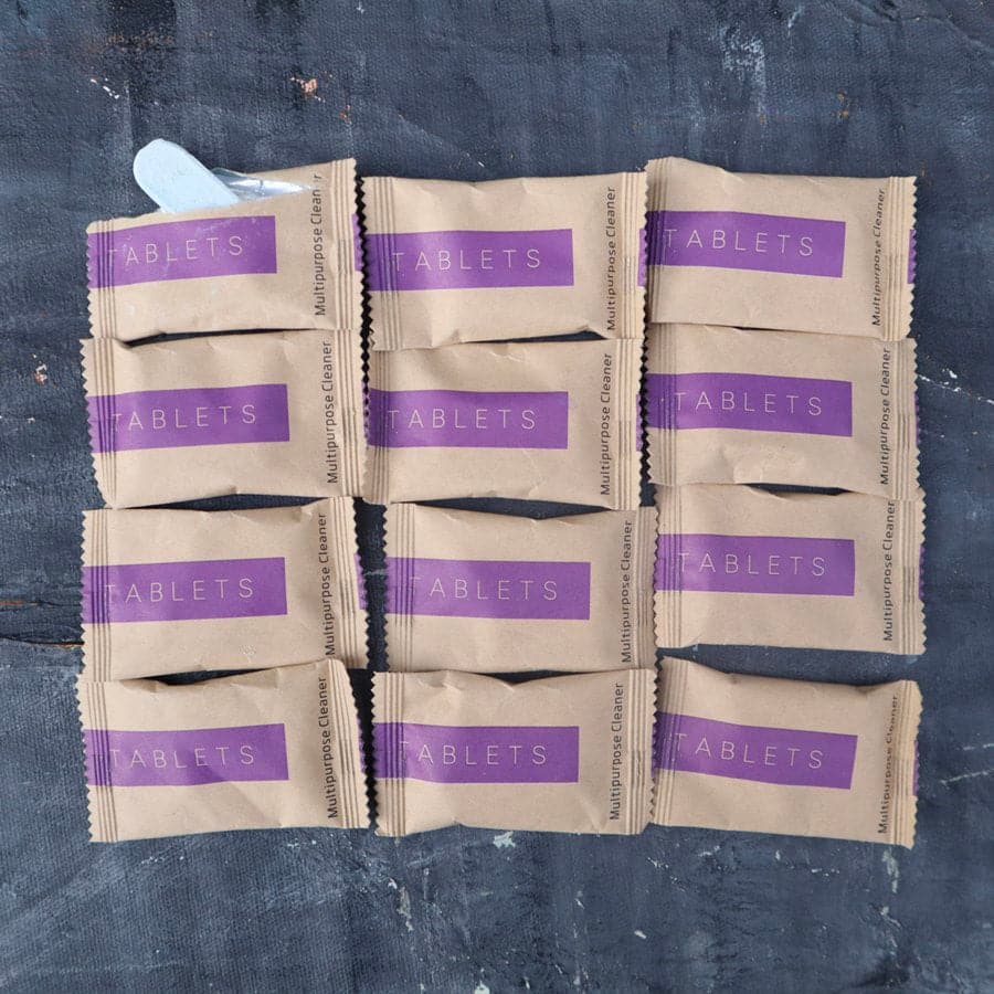 Multiple packets of 'Tablets' with purple labels on a dark surface