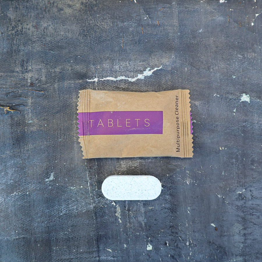 Kraft paper packet labeled 'Tablets' on a textured dark surface