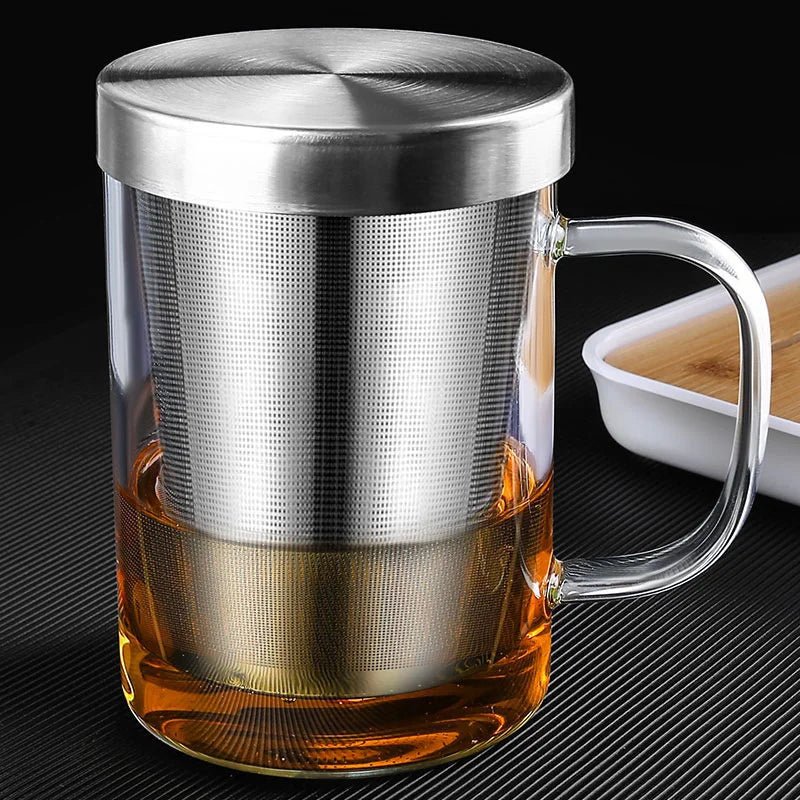 High borosilicate glass travel mug with tea infuser, filter, and sturdy handgrip, ideal for hot and cold beverages.