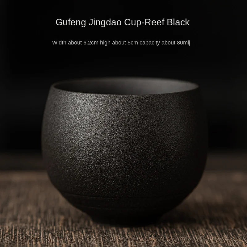 Black ceramic cup labeled 'Gufeng Jingdao Cup-Reef Black' on a dark background