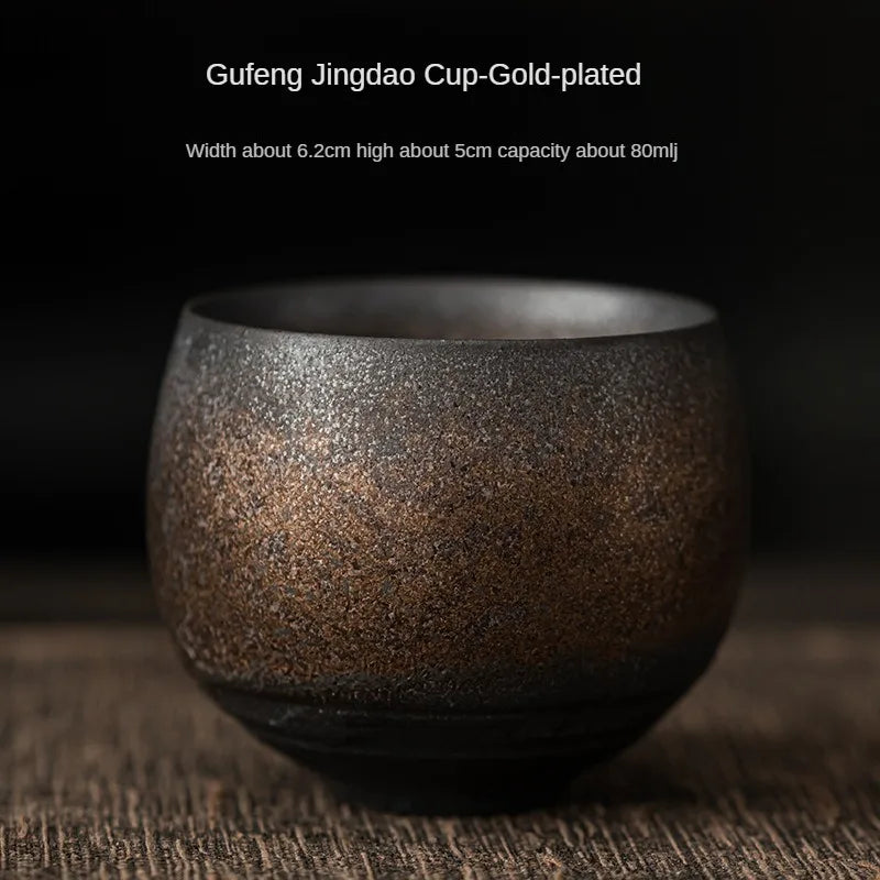 Gold-plated ceramic cup on a dark background