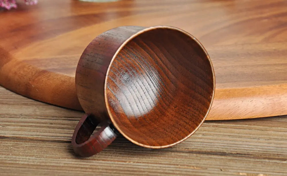 EcoNest 130ml Eco-Friendly Solid Wood Cup with Handle featuring tea inside on a rustic wooden table.