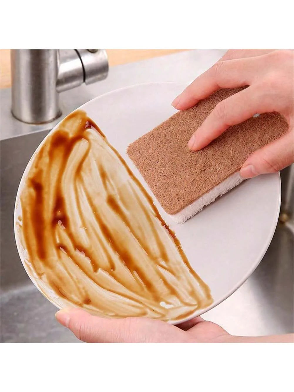 Person cleaning a stained plate with a scrubber under running water.