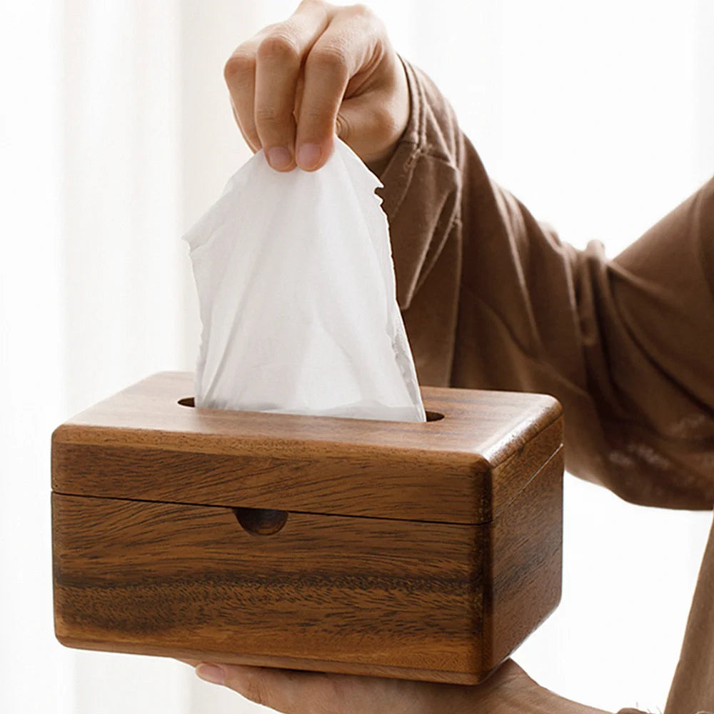 Wooden tissue box with a hand pulling out a white tissue.