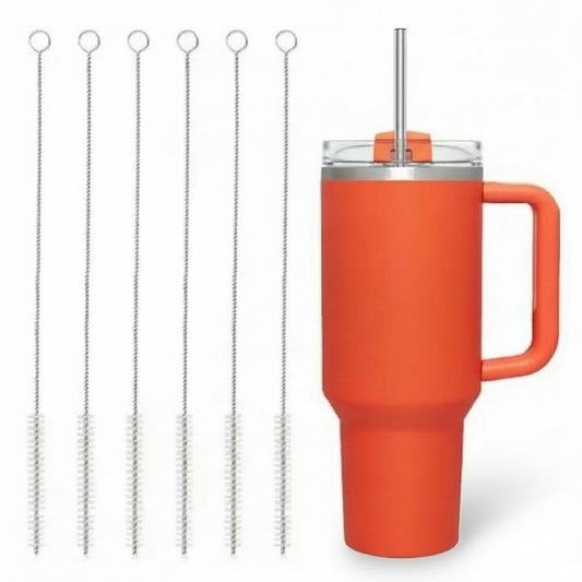 Orange mug with metal straw and cleaning brushes on a white background
