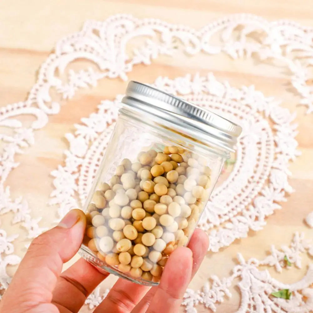 Hand holding a glass jar filled with small round objects on a decorative doily.
