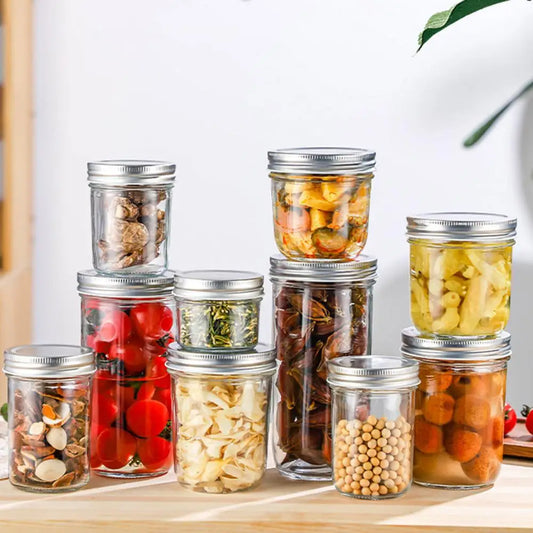 Set of glass jars with metal lids containing various food items on a wooden surface.