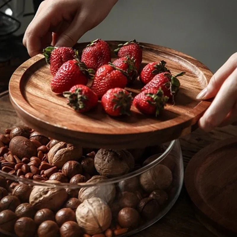 Wooden tiered stand with strawberries and nuts on a wooden surface