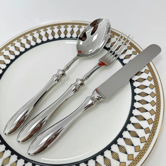 Stainless steel knife, fork, and spoon set by EcoNest Kitchen displayed on eco-conscious table setting