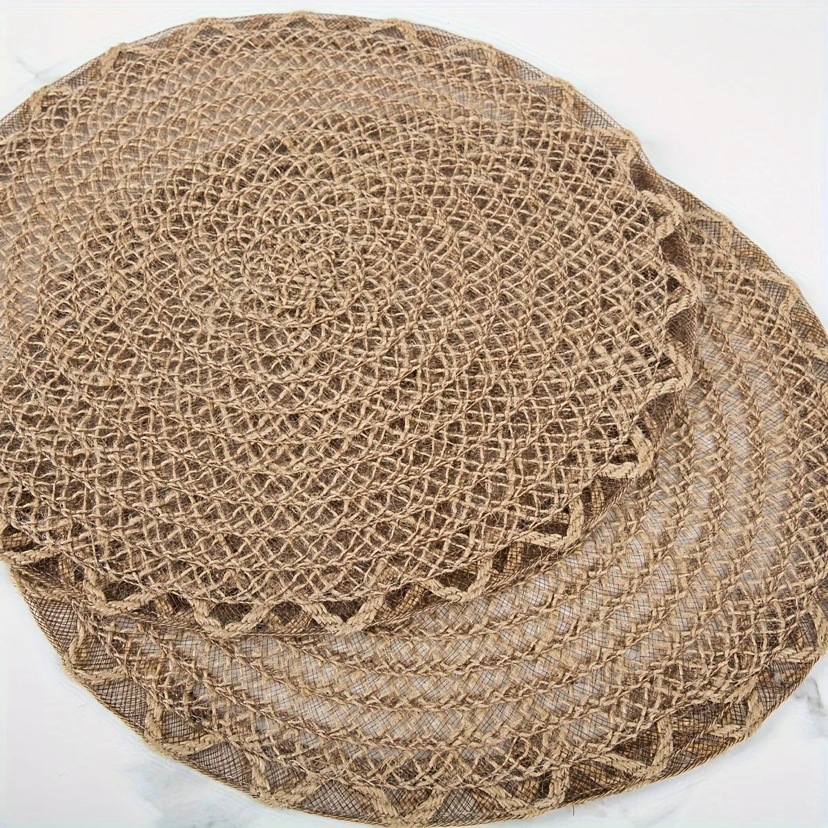 Round jute placemats stacked on a white surface