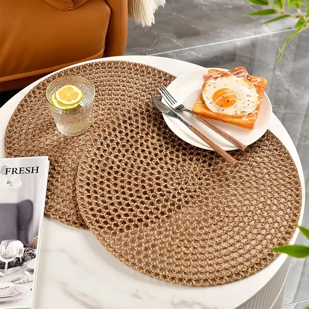 Round woven placemat on a table with a glass of water and lemon, a plate of toast with an egg, and a magazine.