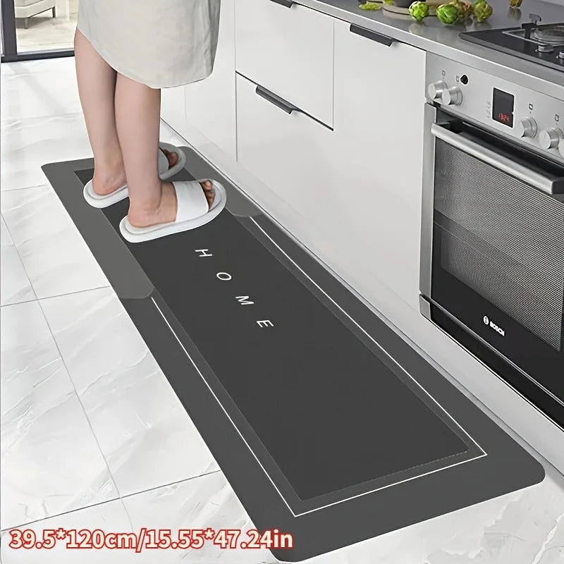 Black kitchen mat with 'HOME' text on a kitchen floor, showing a person wearing white sandals.
