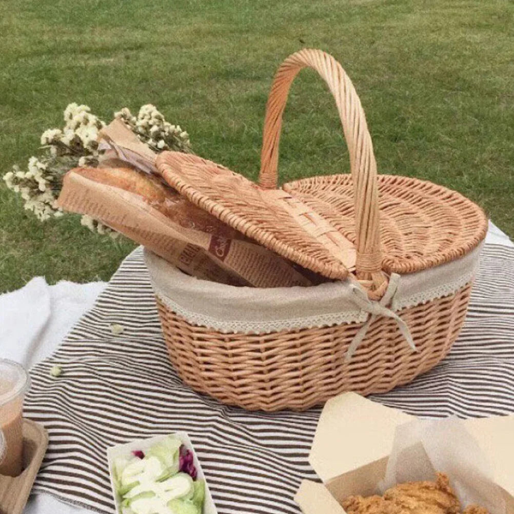 Wicker picnic basket with bread on a striped blanket outdoors