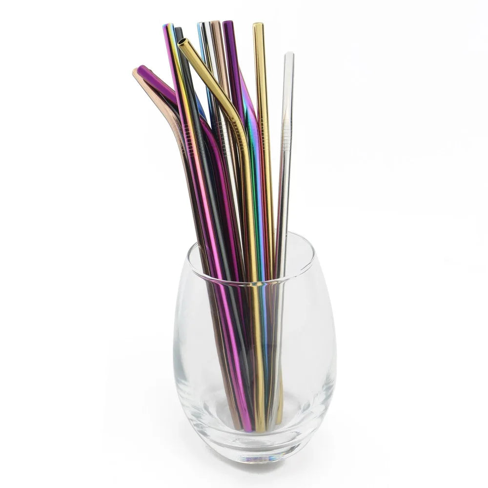 Set of colorful metal straws in a clear glass on a white background