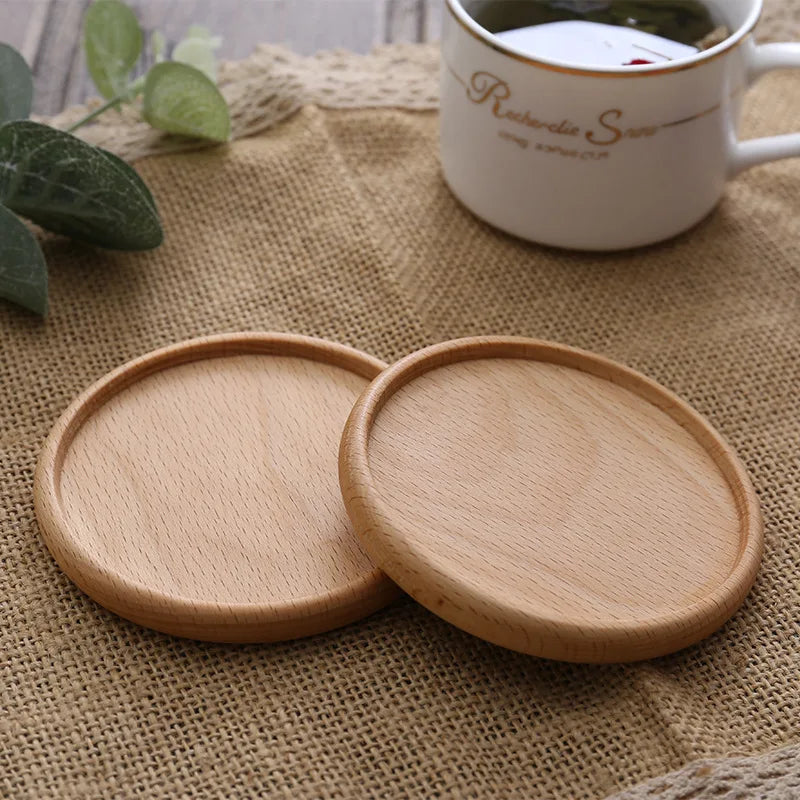 Two wooden coasters on a textured surface with a mug in the background.