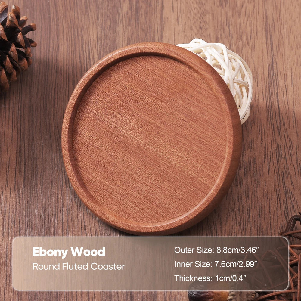 Round fluted coaster made of ebony wood on a wooden surface with text detailing dimensions.