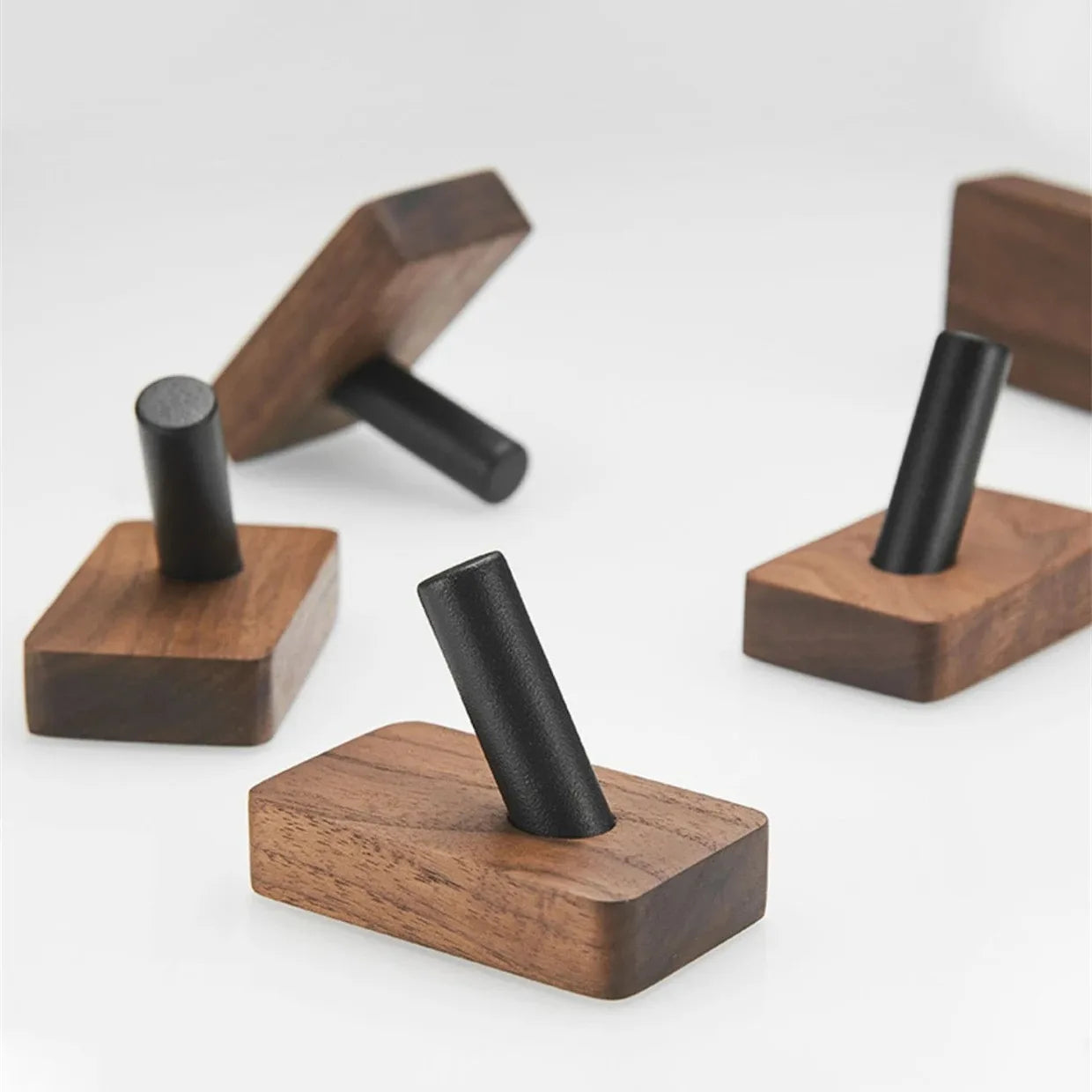 Set of wooden wall hooks with black accents on a white background