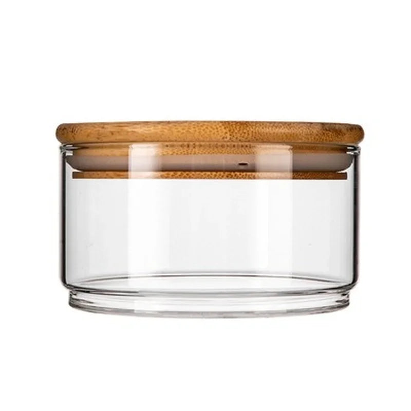 Clear glass jar with a wooden lid on a white background