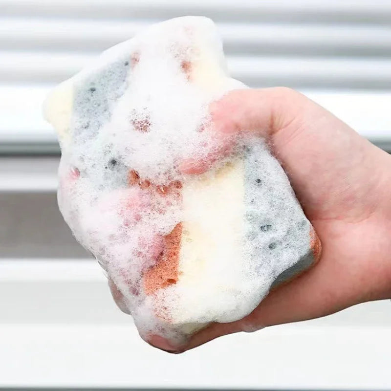 Hand holding a sudsy, multicolored bar of soap against a neutral background