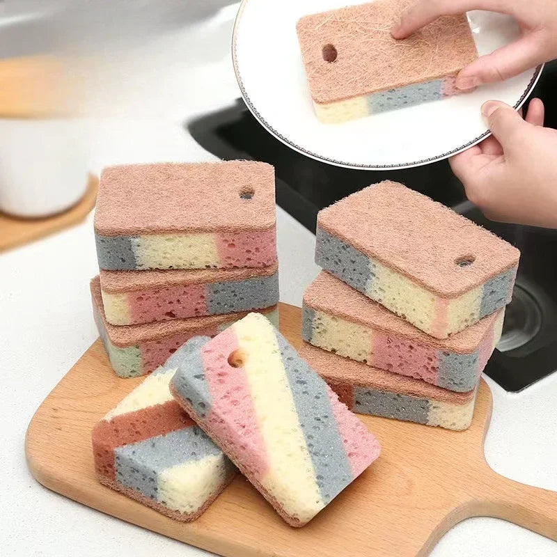 Colorful striped sponges on a wooden cutting board with a blurred kitchen background.