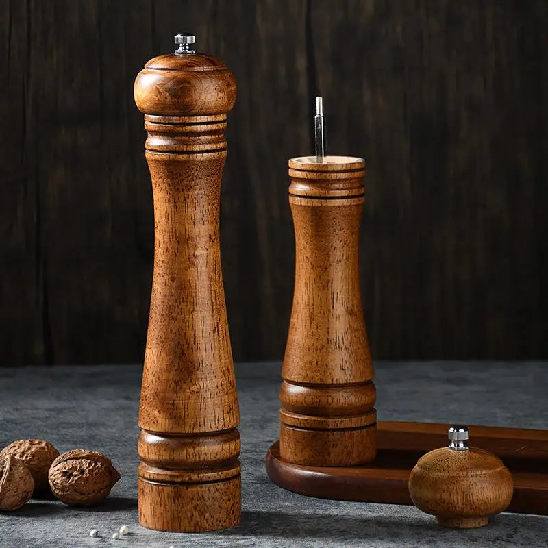 Wooden pepper mill and grinder set on a dark background