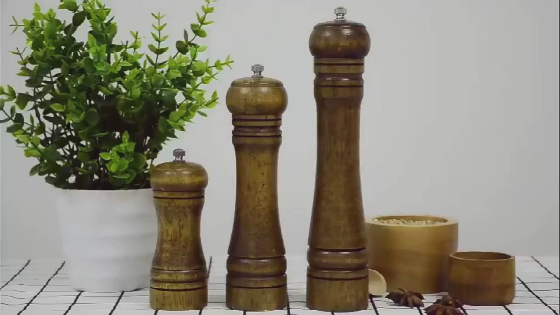 EcoNest Popnova wooden pepper mills in 5, 8, and 10 inches shown grinding pepper and salt; adjustable ceramic core, ergonomic wooden body, eco-friendly and safety-certified.