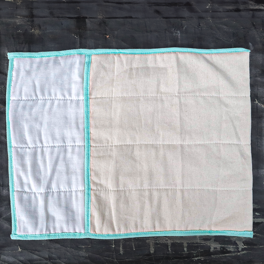Quilted fabric with turquoise border on a dark background