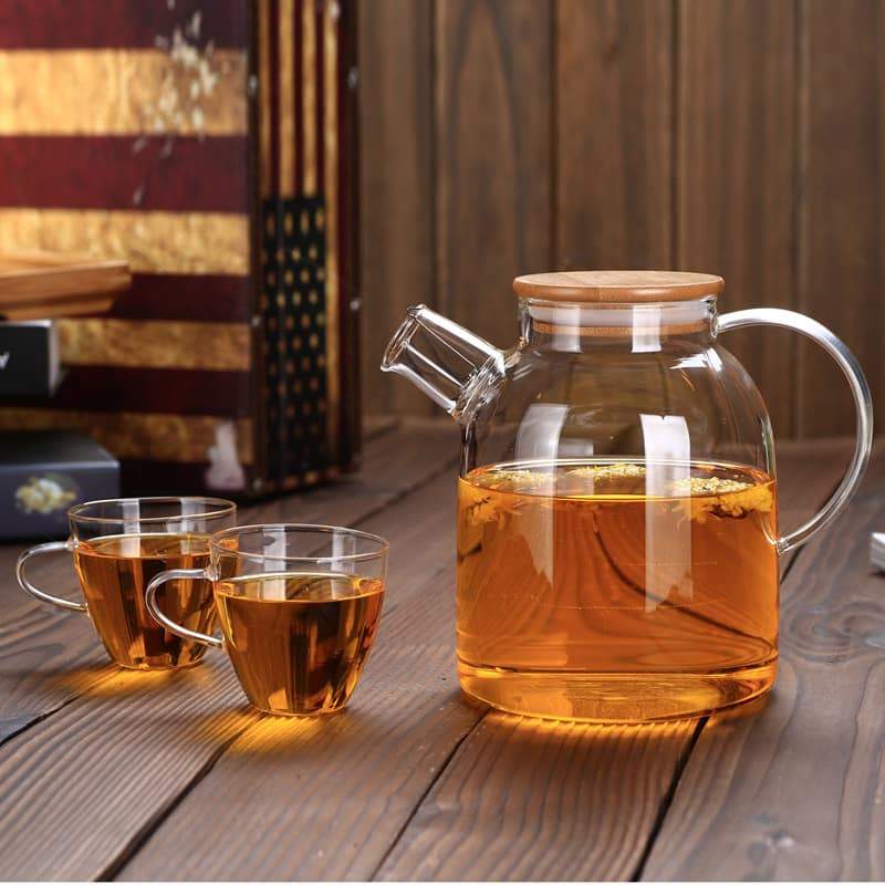 Thermo Glass Teapot 54 Fl Oz | High temperature and shock resistant with bamboo lid, served with two cups of tea.