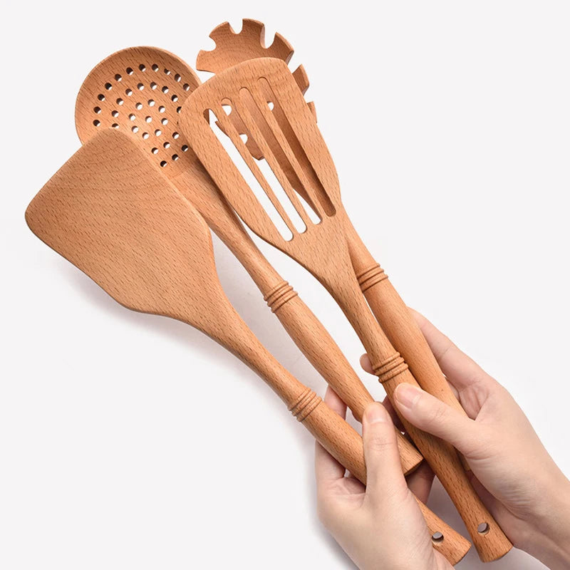 Natural wood kitchen utensils set including spatula and spoon for eco-friendly, non-stick cooking.